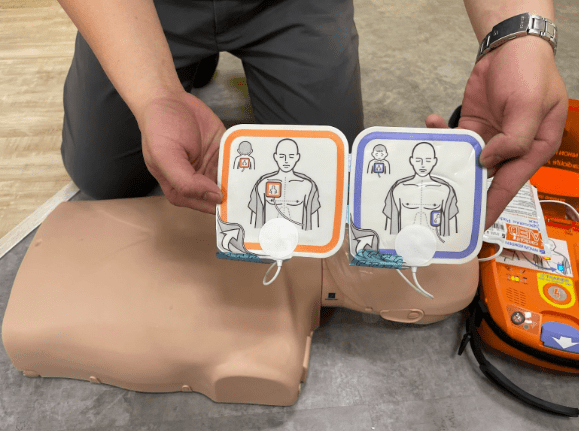 Bước 1. Mở AED, bật AED  lên và gắn các miếng điện cực vào bệnh nhân